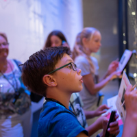 Jonge bezoeker met audiotour in vaste expositie